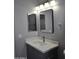 Modern bathroom featuring a stylish vanity, gray cabinets, a sink, and dual mirrors at 17810 W Marshall Ln, Surprise, AZ 85388