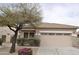 Charming single-story home featuring stone accents, a two-car garage, and manicured landscaping at 17810 W Marshall Ln, Surprise, AZ 85388