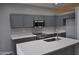 Open kitchen featuring gray cabinets, white countertops, stainless steel appliances, and a central island at 17810 W Marshall Ln, Surprise, AZ 85388