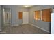 Open-concept living room featuring gray walls, faux-wood floors, and a neutral-toned front door at 17810 W Marshall Ln, Surprise, AZ 85388