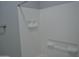 The bright white tiled shower has built in storage shelves for soaps and shampoos at 17810 W Marshall Ln, Surprise, AZ 85388