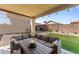 Covered patio with an outdoor sectional sofa, coffee table, and string lights for relaxing outdoor evenings at 18058 W Weatherby Dr, Surprise, AZ 85374
