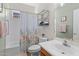This bathroom features a shower-tub combination and a floral shower curtain at 18058 W Weatherby Dr, Surprise, AZ 85374