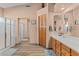 This neutral bathroom features a tub/shower combo with a glass enclosure and light wood cabinetry at 18058 W Weatherby Dr, Surprise, AZ 85374