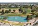 Scenic aerial view of lush community golf course and water feature with surrounding homes and trees at 18058 W Weatherby Dr, Surprise, AZ 85374