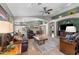 Open-concept living room featuring a large leather sofa, tile flooring, and a view into the kitchen at 18058 W Weatherby Dr, Surprise, AZ 85374