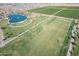 Aerial view of large community park featuring sports fields, pond, and recreation area at 18525 N Larkspur Dr, Maricopa, AZ 85138