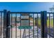 Fenced dog park entrance with posted hours and contact information, providing a secure space for pets to exercise at 18525 N Larkspur Dr, Maricopa, AZ 85138