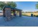 A well-maintained stone picnic area offers a shaded spot for outdoor gatherings and relaxation in a serene park setting at 18525 N Larkspur Dr, Maricopa, AZ 85138
