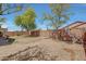 Expansive backyard with gravel, mature trees, and a block wall, perfect for outdoor living at 18590 W Vogel Ave, Goodyear, AZ 85338