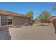 Backyard area with gravel landscaping, outdoor AC unit, and partial view of the house at 18590 W Vogel Ave, Goodyear, AZ 85338