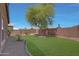 Well-kept backyard featuring a grassy area, trees, and a brick wall perimeter at 18590 W Vogel Ave, Goodyear, AZ 85338