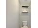 Compact half bathroom with a toilet and convenient shelving for toilet paper storage at 18590 W Vogel Ave, Goodyear, AZ 85338
