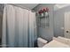 Bathroom with a shower, toilet, vanity, large mirror, and decorative shelves at 18590 W Vogel Ave, Goodyear, AZ 85338