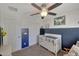 Bedroom with crib and half blue wall features a ceiling fan and closet at 18590 W Vogel Ave, Goodyear, AZ 85338