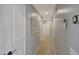 Hallway with tiled floor features a thermostat, doors, and a decorative window at 18590 W Vogel Ave, Goodyear, AZ 85338