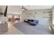 Open concept living room with a plush blue couch, ceiling fan, tile flooring and a view into the kitchen at 18590 W Vogel Ave, Goodyear, AZ 85338