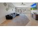 Bright living room with tile floors, a ceiling fan, and a large sofa with a mounted television on the wall at 18590 W Vogel Ave, Goodyear, AZ 85338
