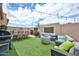 Outdoor backyard featuring a grill, dining set, modern furniture, a fire pit, and string lights above artificial grass at 18650 N 91St Ave # 3701, Peoria, AZ 85382