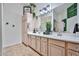 Bathroom featuring a double sink vanity, large mirror, custom lighting, and decorative greenery accents at 18650 N 91St Ave # 3701, Peoria, AZ 85382