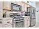 Close-up of a kitchen featuring stainless steel appliances, light wood cabinets, and tile countertops at 18650 N 91St Ave # 3701, Peoria, AZ 85382