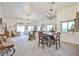 Open-concept living room with stylish chandeliers, a dining area, and views of the outdoor space at 18650 N 91St Ave # 3701, Peoria, AZ 85382