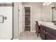 Bathroom showcasing walk-in shower, vanity with chair, tile floors, and walk-in closet at 20592 E Reins Rd, Queen Creek, AZ 85142