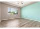 Bedroom with tray ceilings, wood-look flooring, and natural light at 20592 E Reins Rd, Queen Creek, AZ 85142