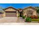 Lovely exterior featuring a well-kept lawn, desert plants, and a two-car garage at 20592 E Reins Rd, Queen Creek, AZ 85142