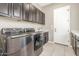 Well-equipped laundry room with cabinets and stainless-steel washer/dryer, offering convenience and storage at 20592 E Reins Rd, Queen Creek, AZ 85142