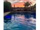 Backyard pool with outdoor seating area offering a relaxing oasis under a vibrant sunset sky at 20592 E Reins Rd, Queen Creek, AZ 85142