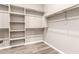 Large walk-in closet featuring built-in shelving and hardwood floors at 20592 E Reins Rd, Queen Creek, AZ 85142