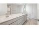 Bright bathroom with double sink vanity, quartz counters, and large mirror at 21352 N 271St Dr, Buckeye, AZ 85396
