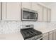 Modern kitchen features stainless steel appliances and stylish backsplash at 21352 N 271St Dr, Buckeye, AZ 85396