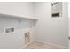 Well-lit laundry room with white walls, ample shelving, and tile flooring at 21352 N 271St Dr, Buckeye, AZ 85396