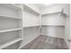 Spacious walk-in closet featuring custom shelving, rods, and carpeted floors for organized storage solutions at 21352 N 271St Dr, Buckeye, AZ 85396
