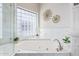 Bright bathroom with a large soaking tub, marble accents, and a stylish glass block window at 21474 N 56Th Ave, Glendale, AZ 85308