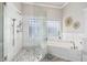 Bathroom features glass shower, large soaking tub, tile floor, and white marble at 21474 N 56Th Ave, Glendale, AZ 85308