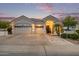 Elegant home exterior with a three-car garage, complemented by manicured landscaping and decorative accents at 21474 N 56Th Ave, Glendale, AZ 85308