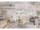 Open-concept living room with a plush sofa, stylish coffee table, and seamless flow into the kitchen and dining area at 21474 N 56Th Ave, Glendale, AZ 85308