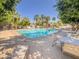 Community pool with lounge chairs and tables, surrounded by lush greenery and palm trees at 2314 E Hidalgo Ave, Phoenix, AZ 85040