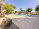 Inviting community pool area with shaded seating, surrounded by palm trees and landscaping at 2314 E Hidalgo Ave, Phoenix, AZ 85040