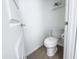A small powder room featuring a white toilet, door, and a modern design at 2314 E Hidalgo Ave, Phoenix, AZ 85040