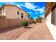 A simple backyard is landscaped with red rock, a brick path, a sturdy brick wall, and some greenery at 2553 E Carob Dr, Gilbert, AZ 85298