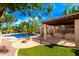 An inviting backyard patio features a built-in grill, a fire pit, and lush landscaping, perfect for outdoor entertaining at 2553 E Carob Dr, Gilbert, AZ 85298