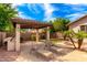 An elegant backyard patio boasts a built-in grill, comfortable lounge chairs, and manicured landscaping, ideal for relaxation at 2553 E Carob Dr, Gilbert, AZ 85298