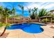 A stunning backyard pool is surrounded by tall palm trees and a covered patio area, creating a private oasis at 2553 E Carob Dr, Gilbert, AZ 85298
