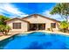 A sparkling backyard pool sits outside a home with a covered patio area and neatly landscaped areas at 2553 E Carob Dr, Gilbert, AZ 85298