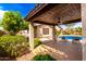 A covered patio offers respite with outdoor seating overlooking a refreshing pool and well-manicured backyard at 2553 E Carob Dr, Gilbert, AZ 85298