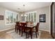 Formal dining room with a dark wood table and chairs, modern lighting, and shuttered windows at 2553 E Carob Dr, Gilbert, AZ 85298